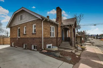 a brick house with a chimney on a street at groovy apartment in the heart of the city in Denver