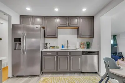 a kitchen with stainless steel appliances and wooden cabinets at 15min to Denver - AirHockey - Arcade - Minigolf - Sleeps10 in Westminster