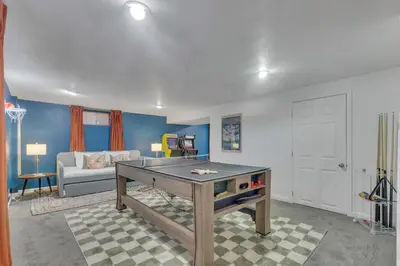 a living room with a ping pong table in it at 15min to Denver - AirHockey - Arcade - Minigolf - Sleeps10 in Westminster