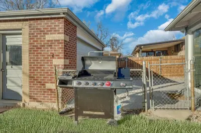 a grill in a yard next to a house at 15min to Denver - AirHockey - Arcade - Minigolf - Sleeps10 in Westminster