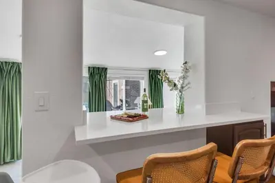 a kitchen with a counter with chairs and a window at 15min to Denver - AirHockey - Arcade - Minigolf - Sleeps10 in Westminster