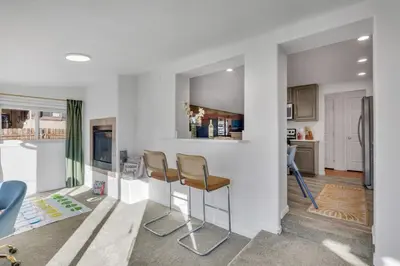 a kitchen with two bar stools in a room at 15min to Denver - AirHockey - Arcade - Minigolf - Sleeps10 in Westminster