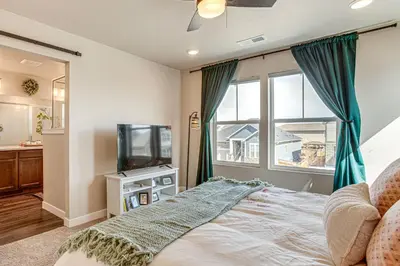 a bedroom with a bed and a tv and a window at Beautiful Home with Bonus Room and Prime Location! in Brighton