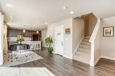 an open living room and kitchen with a dining room and stairs at Beautiful Home with Bonus Room and Prime Location! in Brighton