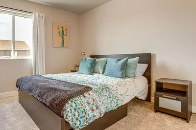 a bedroom with a bed with blue pillows and a window at Beautiful Home with Bonus Room and Prime Location! in Brighton