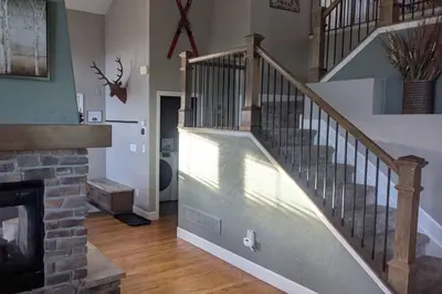 a living room with a staircase and a fireplace at Timber Court in Granby