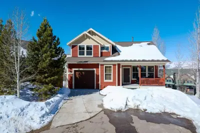 a red house with snow on the driveway at Timber Court in Granby