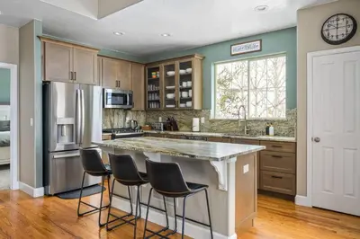 a kitchen with a large island with bar stools at Timber Court in Granby
