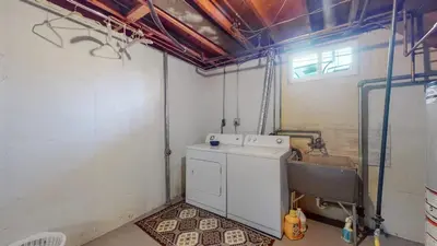 a laundry room with a washing machine and a sink at Spacious Family Home with King Beds and Big Yard in Denver