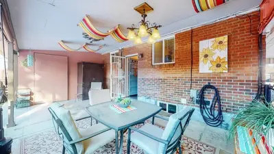 a dining room with a table and chairs and a brick wall at Spacious Family Home with King Beds and Big Yard in Denver
