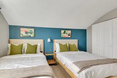 two beds in a bedroom with blue walls at Chic Family Retreat with Game Room backyard with fire pit and minutes to Downtown! in Arvada