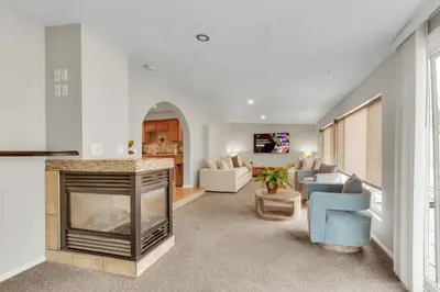 a living room with a fireplace and a blue chair at Chic Family Retreat with Game Room backyard with fire pit and minutes to Downtown! in Arvada