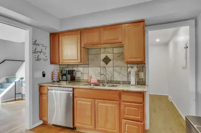 a kitchen with wooden cabinets and a sink at Chic Family Retreat with Game Room backyard with fire pit and minutes to Downtown! in Arvada