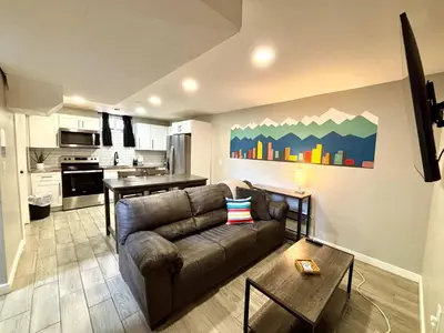 a living room with a couch and a kitchen at Gorgeous 2-King-Bed Lower Unit in Denver in Denver