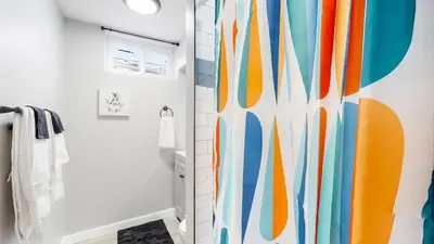 a bathroom with a shower with a colorful shower curtain at Gorgeous 2-King-Bed Lower Unit in Denver in Denver