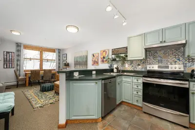 a kitchen with green cabinets and a stove top oven at Premium Unit 1305 - Zephyr Mountain Lodge condo in Winter Park