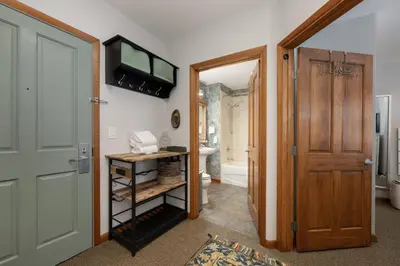 a hallway with a door leading to a bathroom at Premium Unit 1305 - Zephyr Mountain Lodge condo in Winter Park