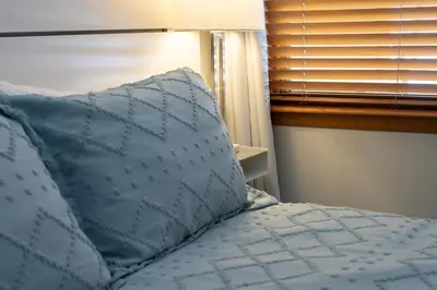 a bed with a blue pillow and a window at Premium Unit 1305 - Zephyr Mountain Lodge condo in Winter Park