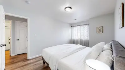 a white bedroom with a bed and a couch at Convenient two bedroom near DIA in Brighton