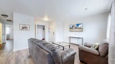 a living room with a leather couch and a table at Convenient two bedroom near DIA in Brighton