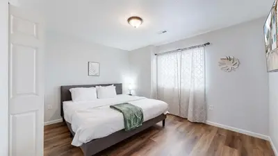 a white bedroom with a bed and a window at Convenient two bedroom near DIA in Brighton