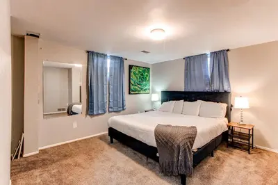 a bedroom with a large bed with blue curtains at Spacious family home in Littleton with fenced yard in Littleton