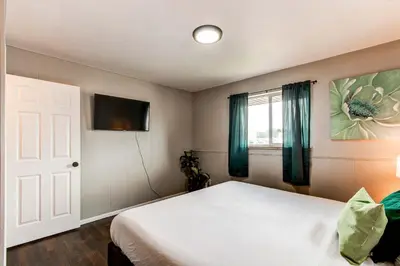 a bedroom with a bed and a tv and a window at Spacious family home in Littleton with fenced yard in Littleton