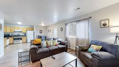 a living room with two couches and a table at Spacious two bedroom apartment near DIA in Brighton