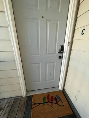 a door with three birds painted on the door mat at Spacious two bedroom apartment near DIA in Brighton