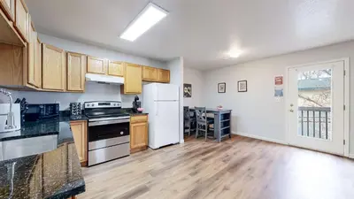 a kitchen with wooden floors and a white refrigerator at Spacious two bedroom apartment near DIA in Brighton