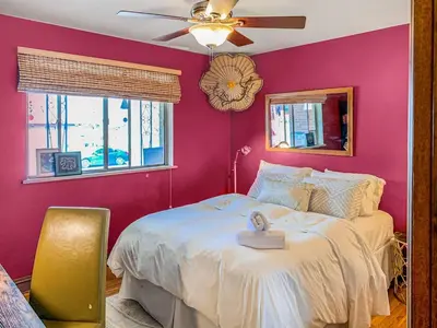 a pink bedroom with a bed and a ceiling fan at Charming two bedroom family home in coveted neighborhood in Denver