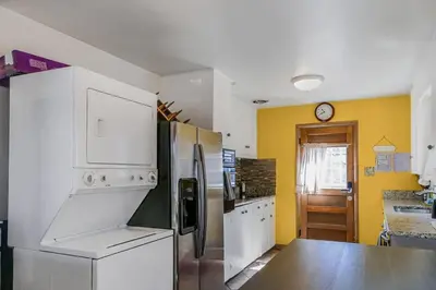 a kitchen with white appliances and yellow walls at Charming two bedroom family home in coveted neighborhood in Denver