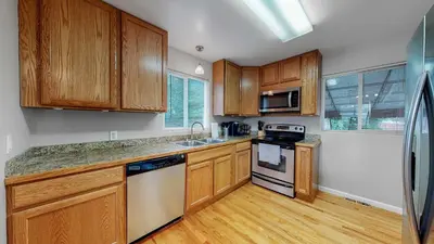 a kitchen with wooden cabinets and a stove top oven at Great two bedroom family spot with convenient access to downtown in Denver