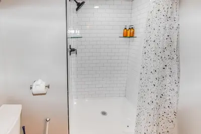 a bathroom with a shower with a glass door at Cozy two bedroom basement unit near light rail in Denver