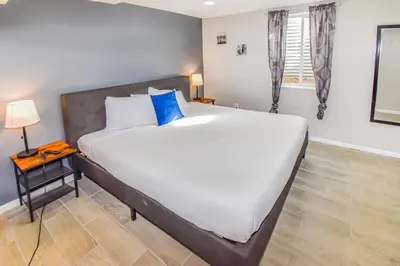 a bedroom with a large bed with blue pillows at Cozy two bedroom basement unit near light rail in Denver