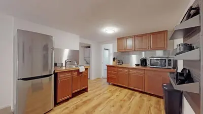 a kitchen with wooden cabinets and a stainless steel refrigerator at Cozy two bedroom basement unit near light rail in Denver