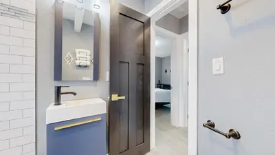 a small bathroom with a sink and a door at Spooky Victorian Family house with four bedrooms central to downtown in Denver
