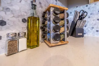 a kitchen counter with a bottle of wine and spices at Near Airport, 3BR, Stock Tank Pool, Mini-Golf, Game Rm in Commerce City