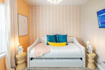 a childs room with a white chair with blue pillows at Near Airport, 3BR, Stock Tank Pool, Mini-Golf, Game Rm in Commerce City