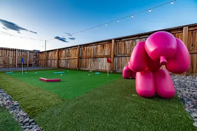 a large pink elephant statue sitting on the grass at Near Airport, 3BR, Stock Tank Pool, Mini-Golf, Game Rm in Commerce City
