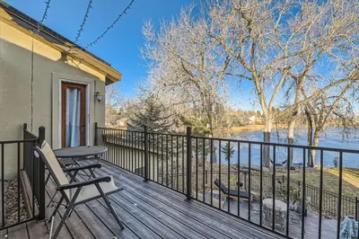 a deck with a table and chairs and a view of a river at Heron Pond in Broomfield