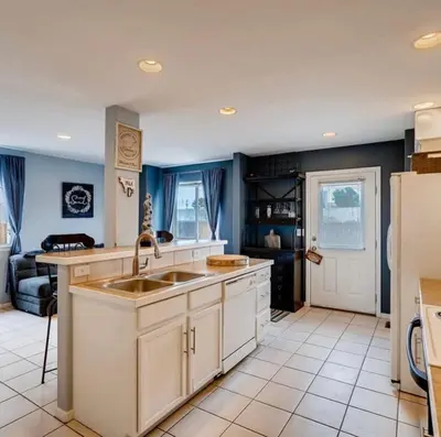 a kitchen with a sink and a refrigerator at Charming Family Home with Cozy Retreat in Denver