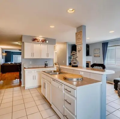 a kitchen with a sink and a living room at Charming Family Home with Cozy Retreat in Denver