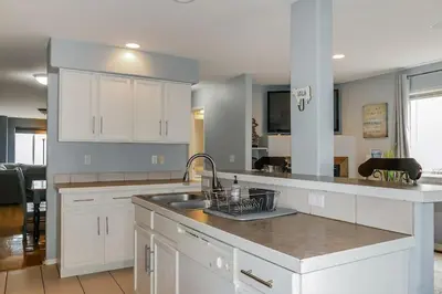 a kitchen with white cabinets and a sink at Charming Family Home with Cozy Retreat in Denver