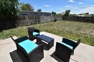 a patio with three chairs and a table and a fence at Dog Friendly and Family Sized Home in Denver Perfect for Your Furry Friend in Denver