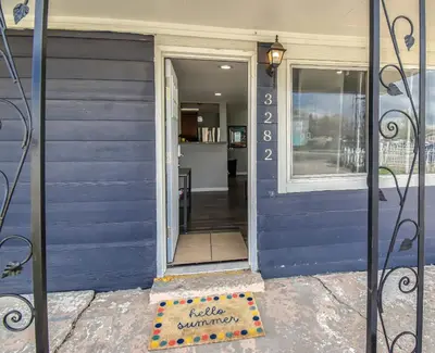 a blue house with a sign in front of a door at Dog Friendly and Family Sized Home in Denver Perfect for Your Furry Friend in Denver