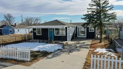 a small blue house with a white picket fence at Dog Friendly and Family Sized Home in Denver Perfect for Your Furry Friend in Denver