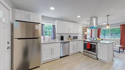 a kitchen with white cabinets and stainless steel appliances at Southwest Charm Spacious Family Home Near Denver in Denver