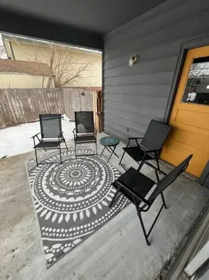 three chairs sitting on a rug in front of a house at Spacious Arvada Family Home with King Beds and Office in Arvada