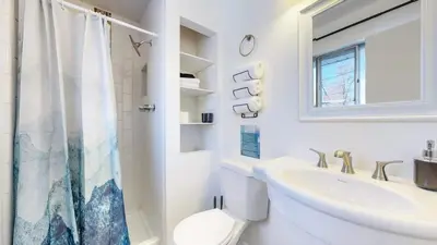 a white bathroom with a sink and a toilet at Spacious Arvada Family Home with King Beds and Office in Arvada